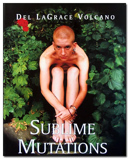 Devant un fond de diverses plantes toutes en feuilles d'un vert profond, une personne jeune est assise, nue. Nous ne voyons rien de son corps hormis son visage au crâne rasé, roux, de multiples piercings aux oreilles, ses bras se joignant par devant ses chevilles nues.